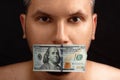 The man`s mouth is sealed with dollars, money. The concept of buying silence, corruption, lobbyists for money Royalty Free Stock Photo