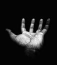 A man`s open hand on a dark background. Use for creative work by adding features to the hand.