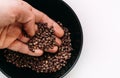 Man`s palm taking a scented Sichuan pepper from the bowl on the white table. Sichuan pepper or Chinese pepper or Timur or Nepali