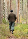 Man`s silhouette in the forest, swampy forest background, the land is covered with plants characteristic of the swamp