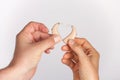 A man`s and a woman`s hand forming a heart from hearing aids