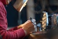 Man with safety glasses repairing motheboard with soldering iron