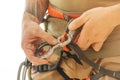 Man in safety harness attaches a figure of eight device to carabiner. Royalty Free Stock Photo