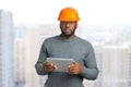 Man in safety helmet and computer tablet. Royalty Free Stock Photo