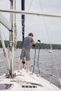 Man on a sailboat holding rope docking boat Royalty Free Stock Photo
