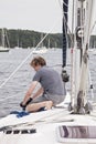 Man on sailboat tying a rope
