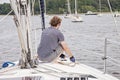 Man on sailboat tying a rope to cleat