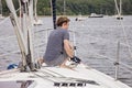 Man on sailboat tying a rope to cleat