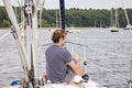 Man on sailboat tying a rope to cleat