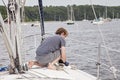 Man on sailboat tying a rope to cleat
