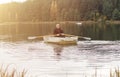 Man sailing or floating in boat and rowing oars on lake