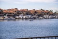 A man sailing a small motor boat at Huntington Harbour with boats and yachts docked in Huntington Harbour and homes Royalty Free Stock Photo