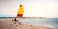 A man sails on the land in buggy near the sea during windy winter day