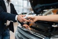 Man and salesgirl choosing auto in car dealership Royalty Free Stock Photo