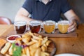 Man sampling variety of seasonal craft beer in pub. Beer samplers in small glasses individually placed in holes Royalty Free Stock Photo