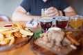 Man sampling variety of seasonal craft beer in pub. Beer samplers in small glasses individually placed in holes Royalty Free Stock Photo