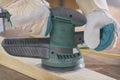 Man sanding a wood with orbital sander Royalty Free Stock Photo