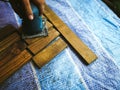 Man sanding wood with square sander in a workshop. Royalty Free Stock Photo