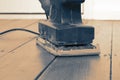 Man sanding wooden floor with an electric sander. Royalty Free Stock Photo