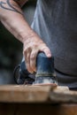 Man is sanding a wooden plank Royalty Free Stock Photo