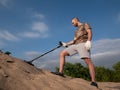 Man on a sandy ground with a metal detector looking for treasure on a sunny summer day Royalty Free Stock Photo