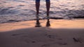 A man on a sandy shore slowly walks into the water Royalty Free Stock Photo