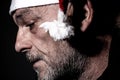 man with Santa Claus hat profile shot in the foreground with a melancholy expression, Christmas is coming. Royalty Free Stock Photo