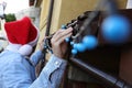 Man in Santa hat decorating house with Christmas lights outdoors, selective focus Royalty Free Stock Photo