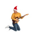 Man in Santa hat jumping with electric guitar on white background. Christmas music Royalty Free Stock Photo