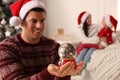 Man in Santa hat with snow globe at home Royalty Free Stock Photo