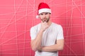 Man in santa hat touch beard on thinking face Royalty Free Stock Photo