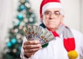 Man in Santa's hat holding money, hand in focus Royalty Free Stock Photo