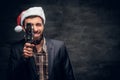 A man in Santa`s hat holds the old 8mm video camera. Royalty Free Stock Photo