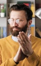 Man sarcastic applause. Vertical video of gloomy skeptical bearded man in glasses in office or apartment room