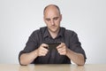 Man sat at desk playing on phone Royalty Free Stock Photo