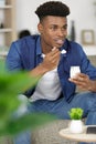 man sat on sofa eatning yoghurt Royalty Free Stock Photo