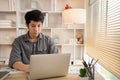 Man sat typing away on a laptop in his office with a determined look on his face Royalty Free Stock Photo