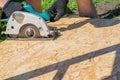 A man sawing a Board with a power tool, chips fly