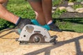 Man sawing a Board with a power tool, chips fly in all directions. Construction, wood processing