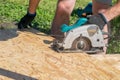 A man sawing a Board with a power tool, chips fly