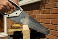 Man sawing wood outside using a hand saw Royalty Free Stock Photo