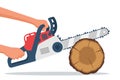 A man saws a log with a chainsaw. The lumberjack holds a gasoline chain saw