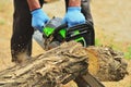 A man saws a log chainsaw, a piece of deck Royalty Free Stock Photo