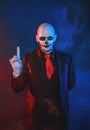 Man with scary skull Halloween make up dead day calavera style on blue smoke background Royalty Free Stock Photo