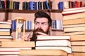 Man, scientist looks at hourglass. Man on serious and shocked face watching time is going over, bookshelves on Royalty Free Stock Photo