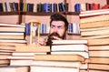 Man, scientist looks at hourglass. Time flow concept. Teacher or student with beard studying in library. Man on serious Royalty Free Stock Photo