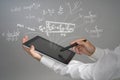 Man scientist or student holding tablet PC and working with various high school maths and science formulas. Royalty Free Stock Photo