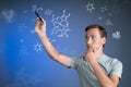 Man scientist with stylus or pen working with chemical formulas on blue background.