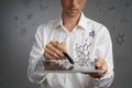 Man scientist with tablet pc and stylus or pen working with chemical formulas on gray background.