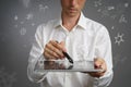 Man scientist with tablet pc and stylus or pen working with chemical formulas on gray background. Royalty Free Stock Photo